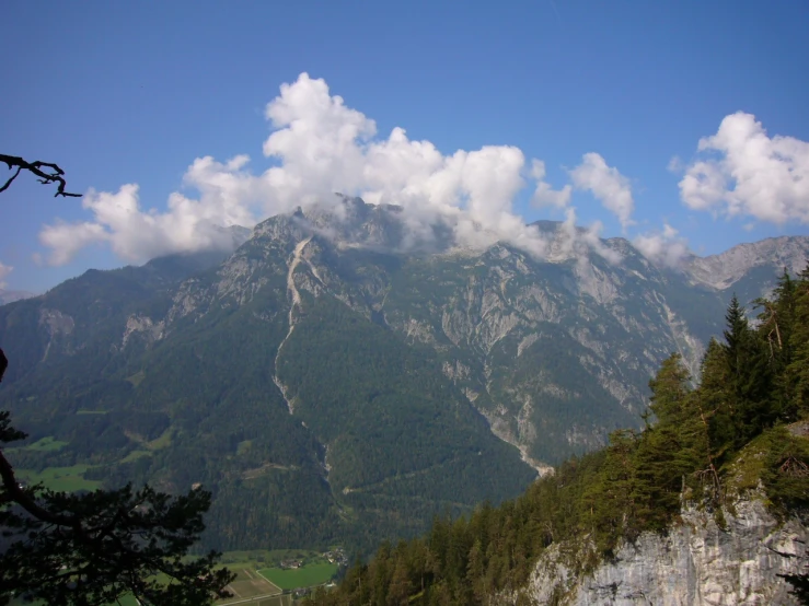 a mountain range with a few clouds in the sky