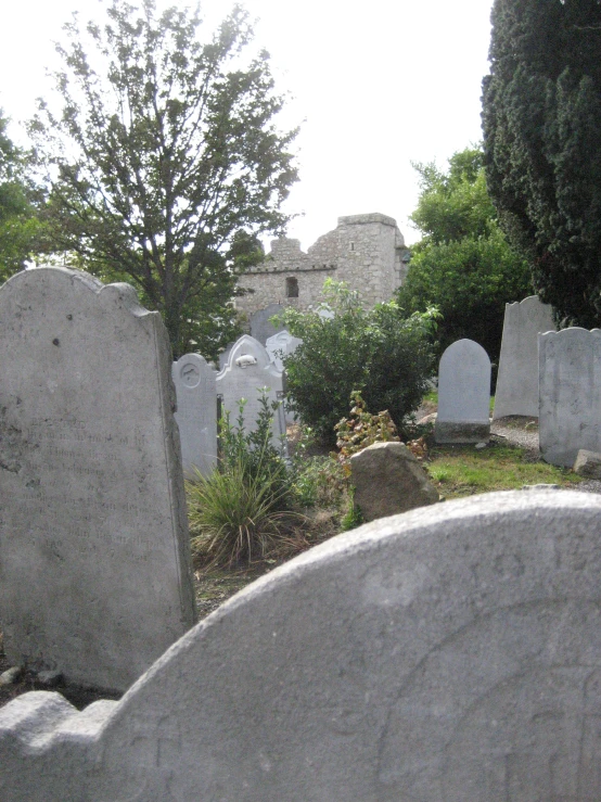 a cemetery with multiple stone headstones sitting on the ground