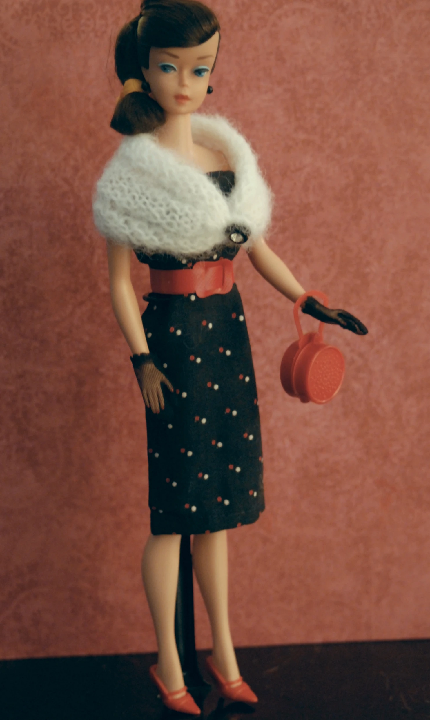 a doll with a hat and a red purse