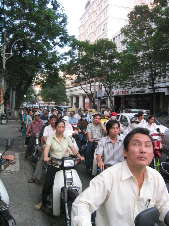 many people are riding motor scooters on the street