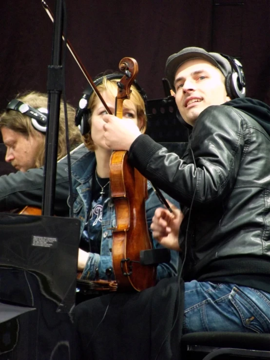 the man and woman sit together, playing instruments