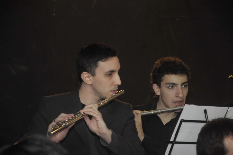 two men sitting with trumpets in their hands