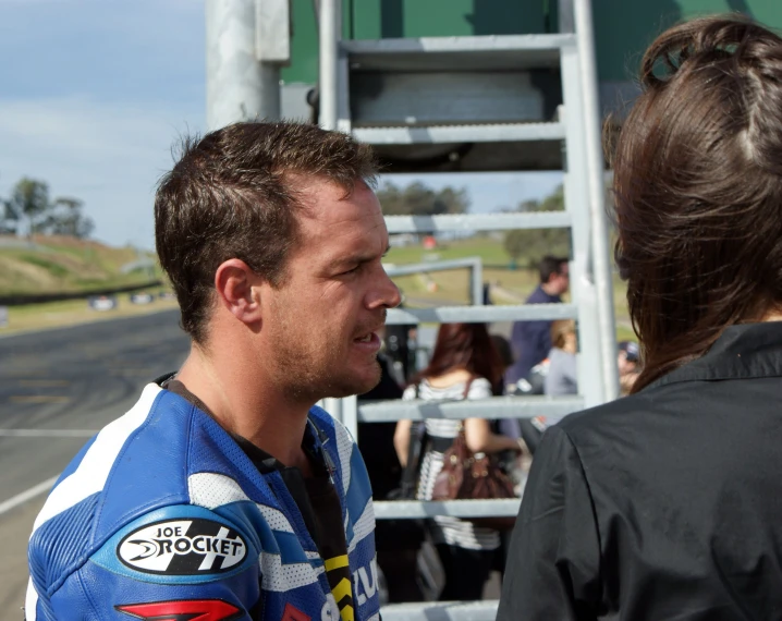 a man is wearing a blue jersey and talking to a woman