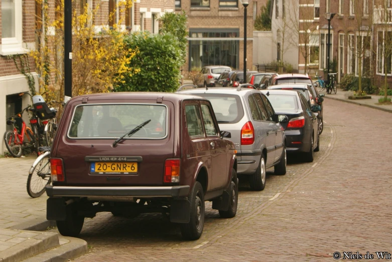 the car with the back door open is parked in traffic on the side of the street