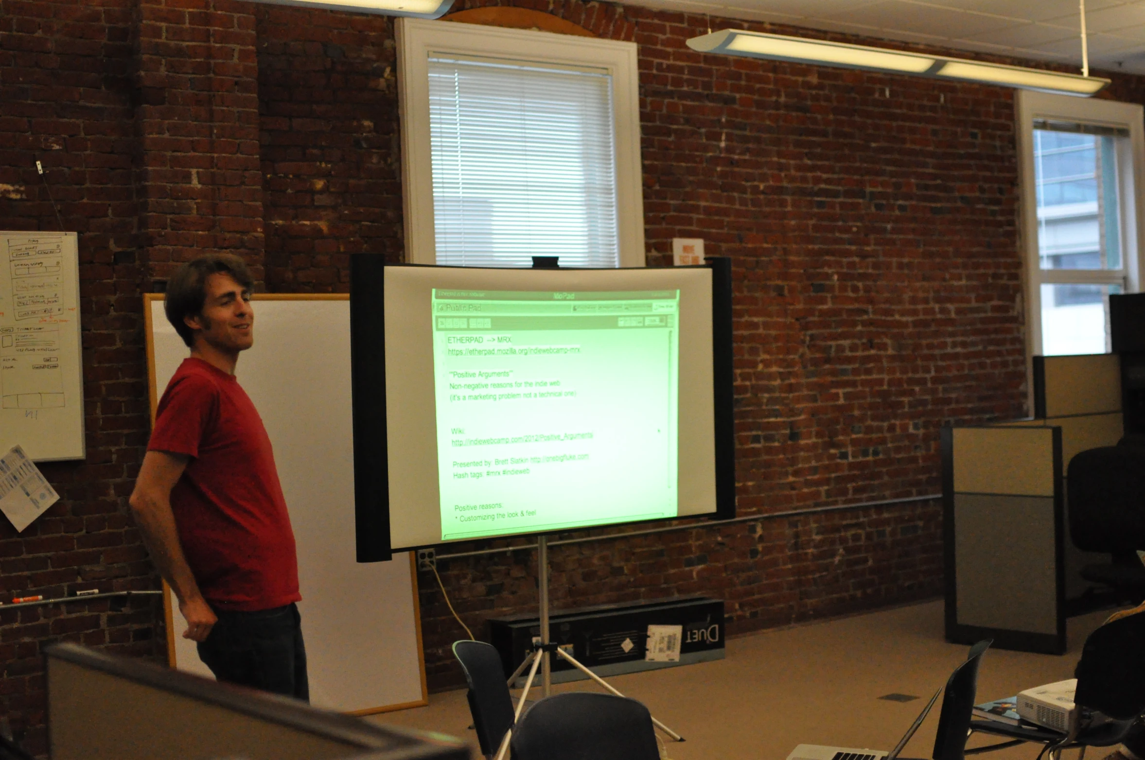 a man standing in front of a projector screen