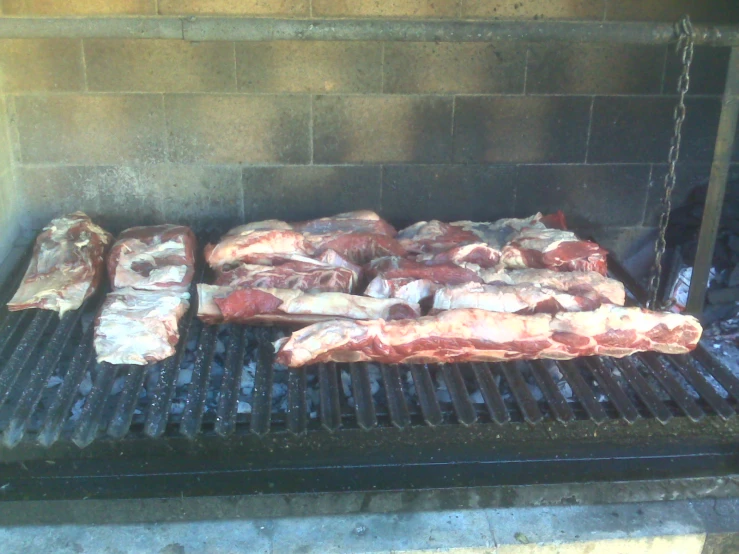 two meats being cooked on a grill over charcoal