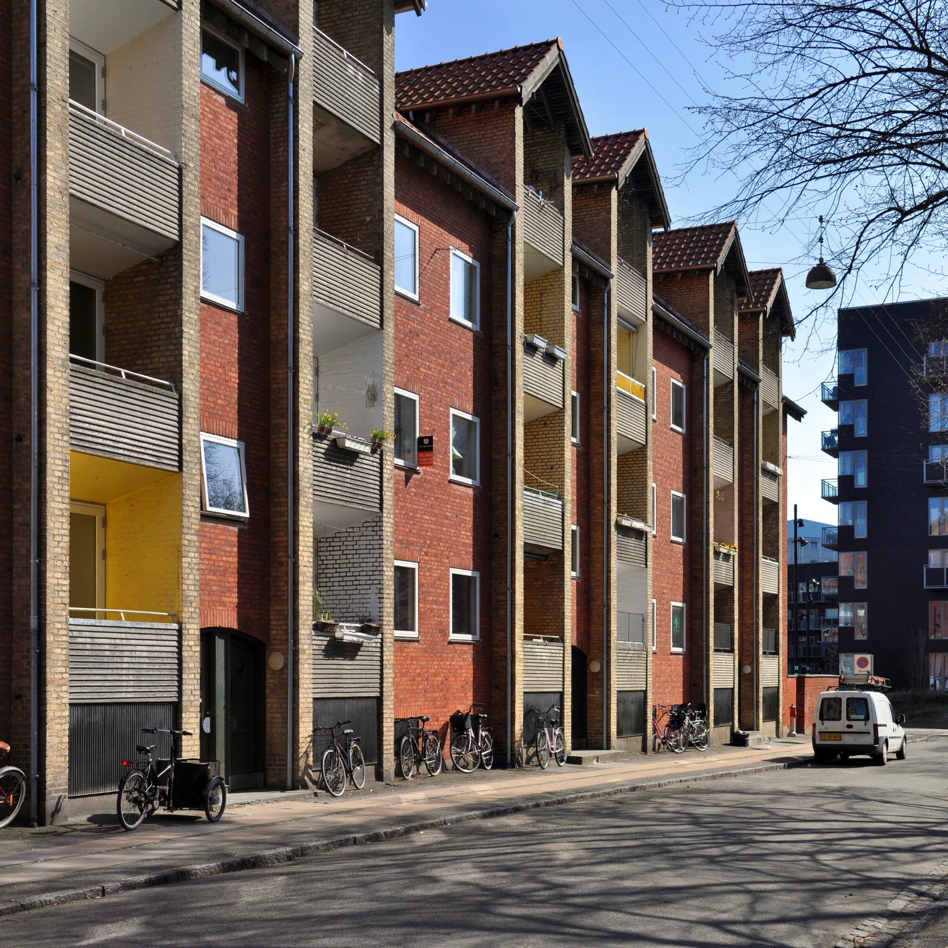 the street with bicycles parked on the buildings is empty