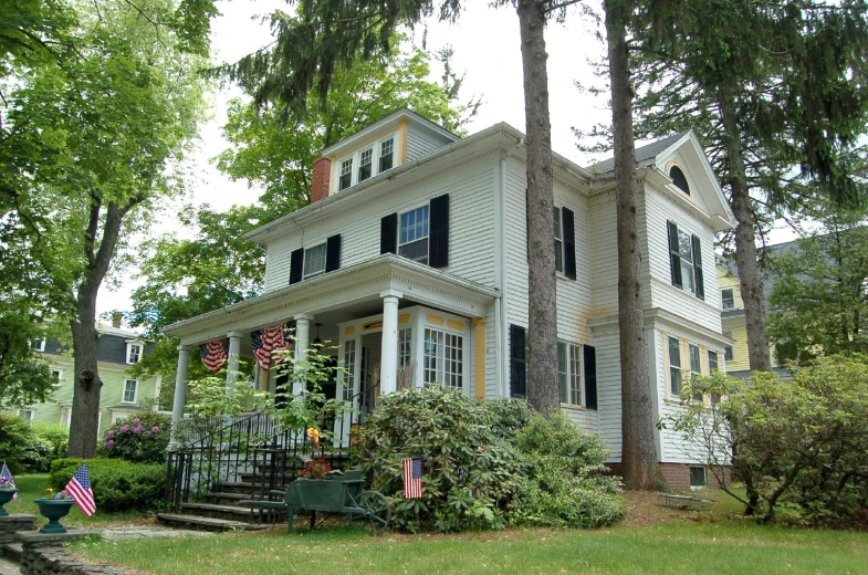 a large house that is sitting under some trees