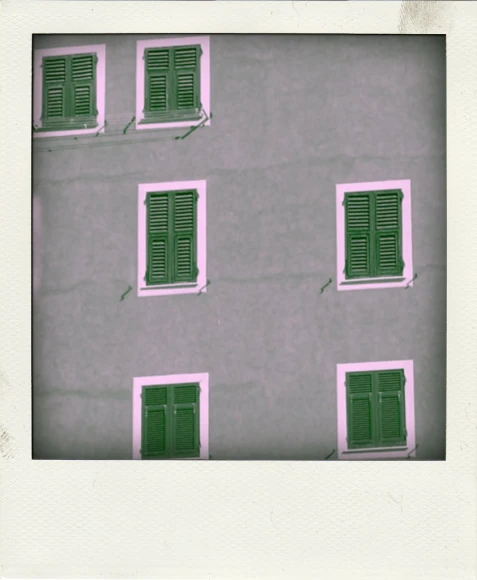 some green shutters and windows on the side of a building