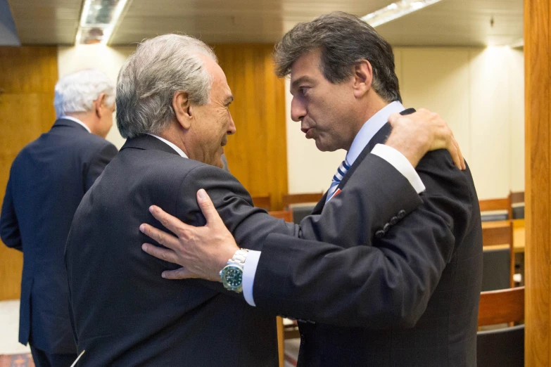 two men in suits emce while standing next to each other