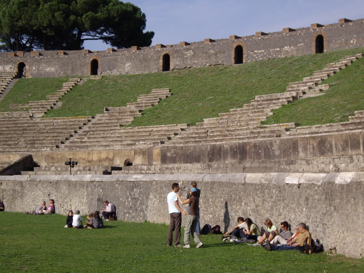 people sit and walk around a roman theatre