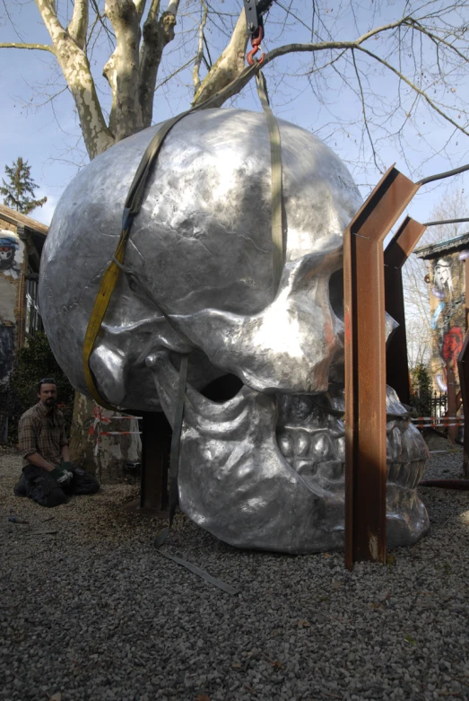 a large silver and black statue sitting on top of a hill