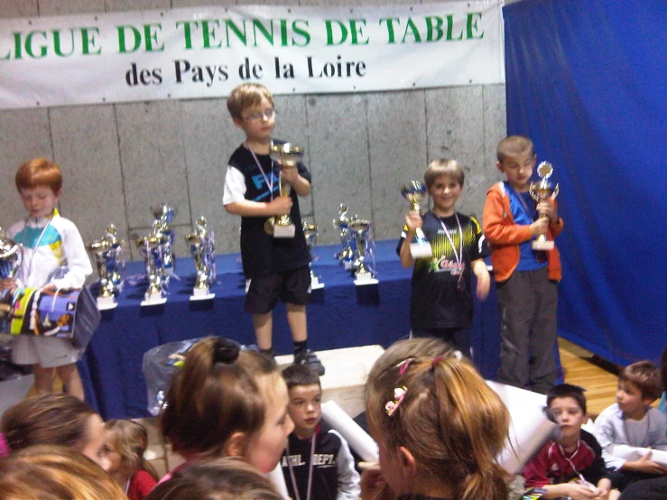 the boy's are holding trophies in front of the crowd