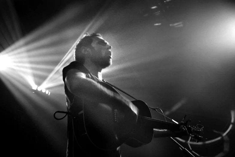 a man with a guitar on stage