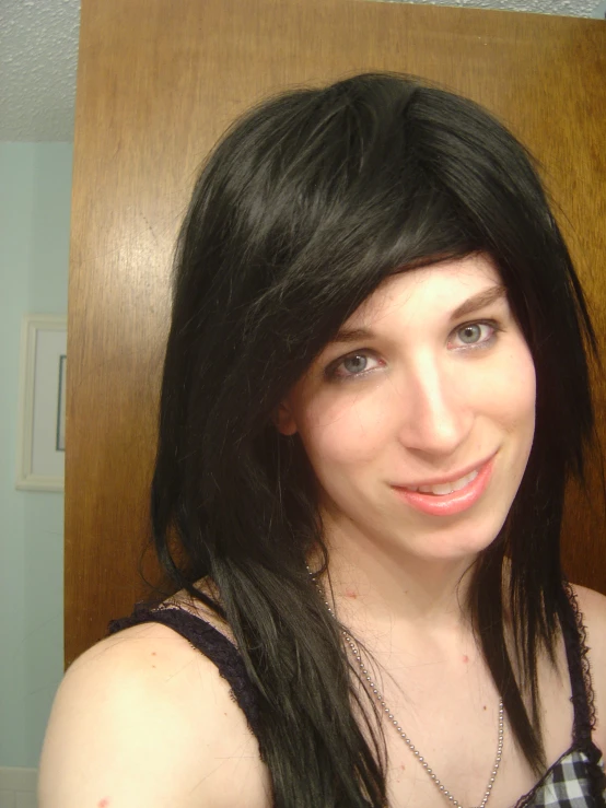 a woman with dark hair wearing black dress posing for a picture