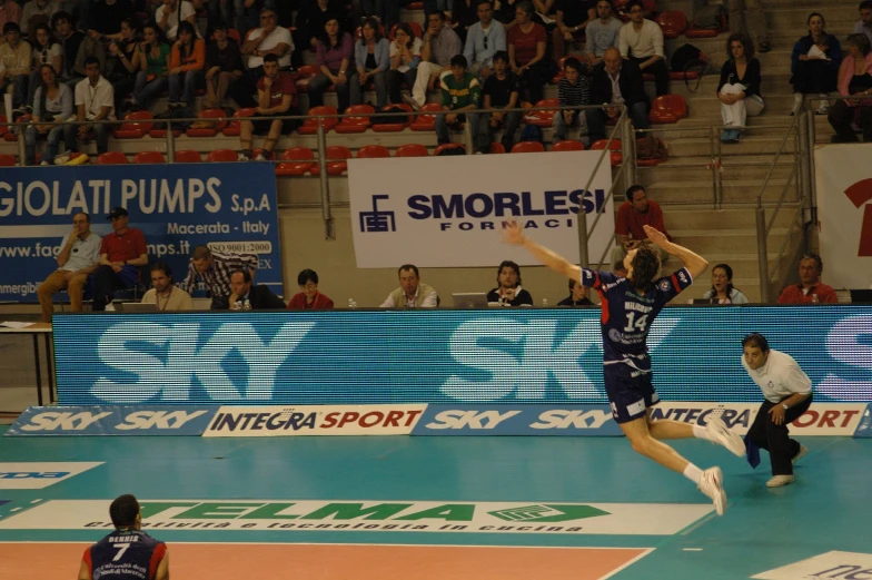 two men in the air in front of people in chairs at a sporting event