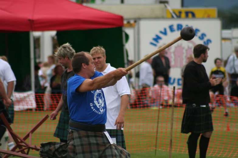 a man in a kilt swinging a baseball bat