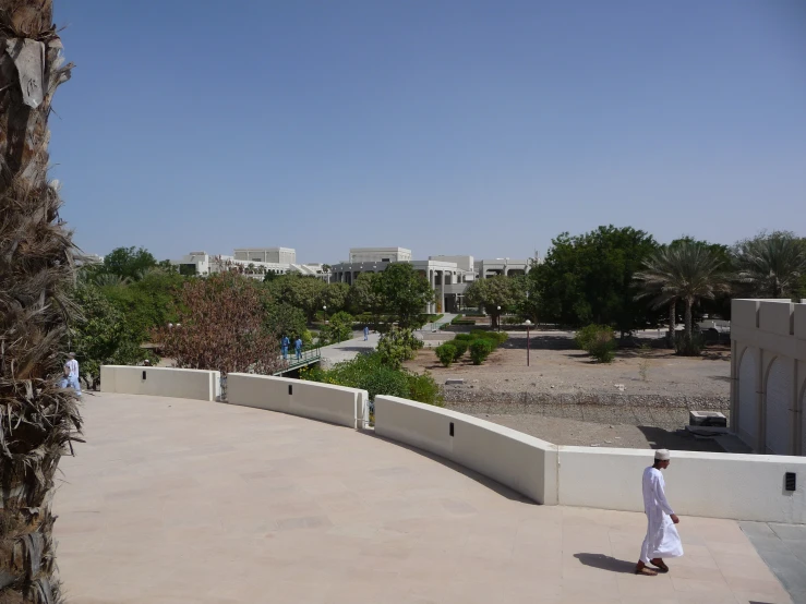 a man walking down the sidewalk towards town