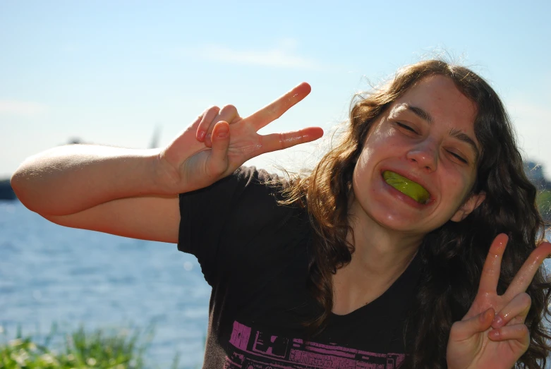 a woman making an odd hand gesture with an apple in front of her