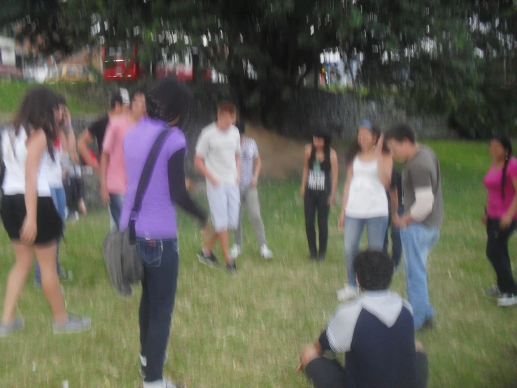 several people standing and sitting in a field