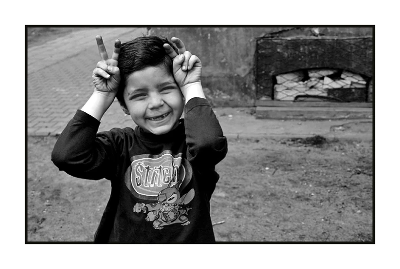 a boy standing and holding his hands on top of his head