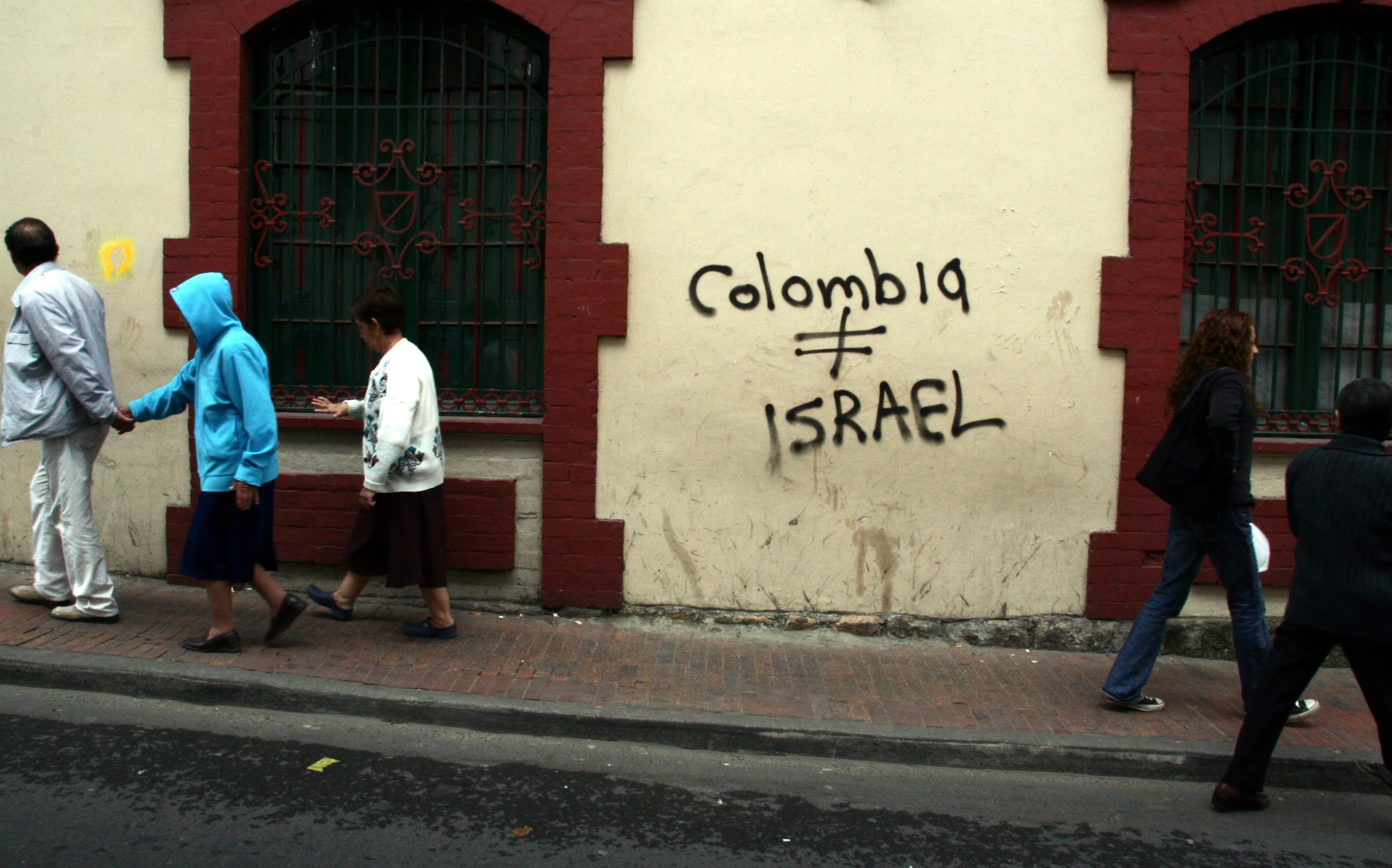 a group of people on a sidewalk next to a building