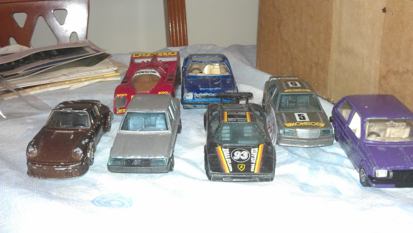 a bunch of toy cars are laying on the bed