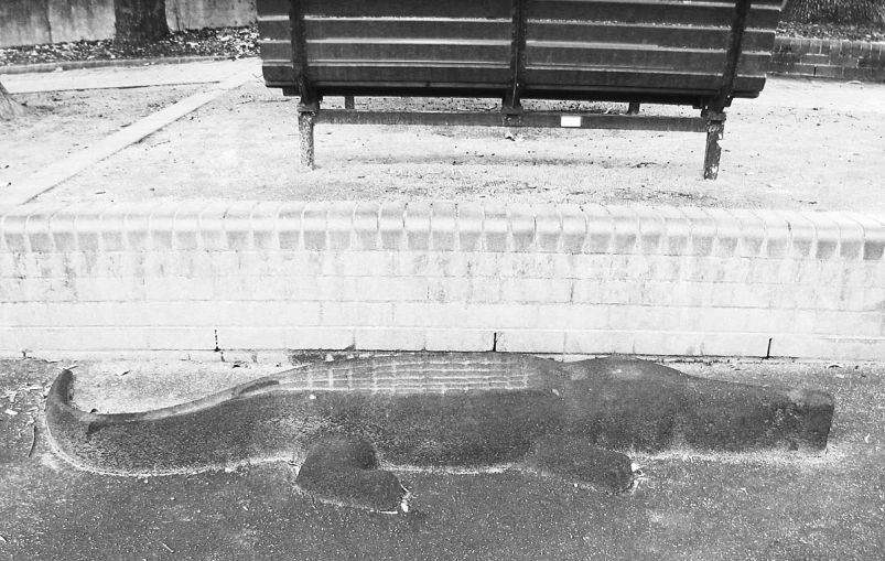 a empty bench sitting on top of a wet street