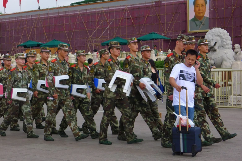 soldiers marching and carrying large sign on the street