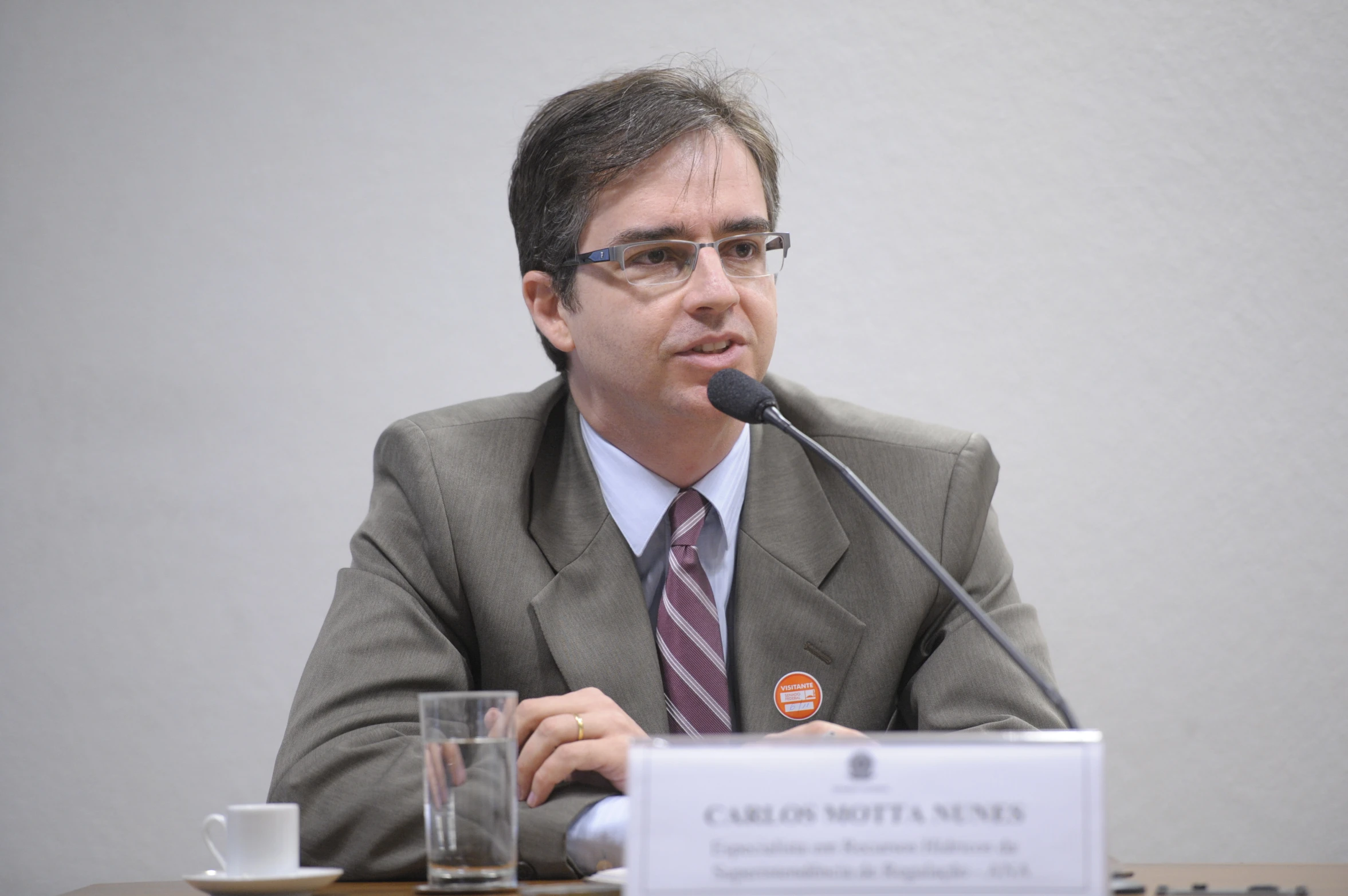 a man with glasses in front of a microphone