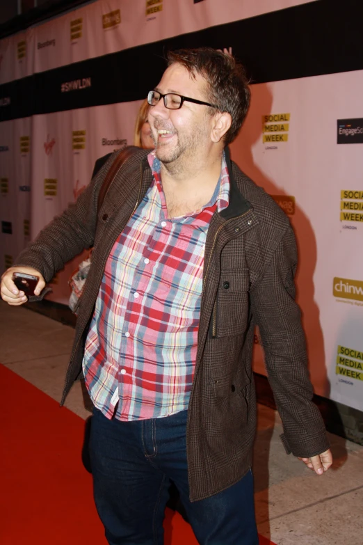 the man smiles while holding his glass