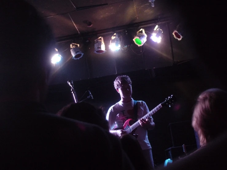 the musician is in a dark room with his guitar