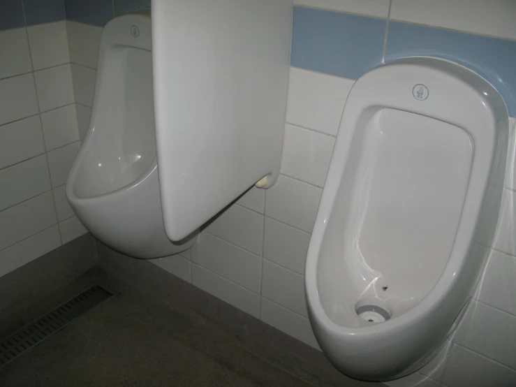 two urinals are hanging up in a bathroom