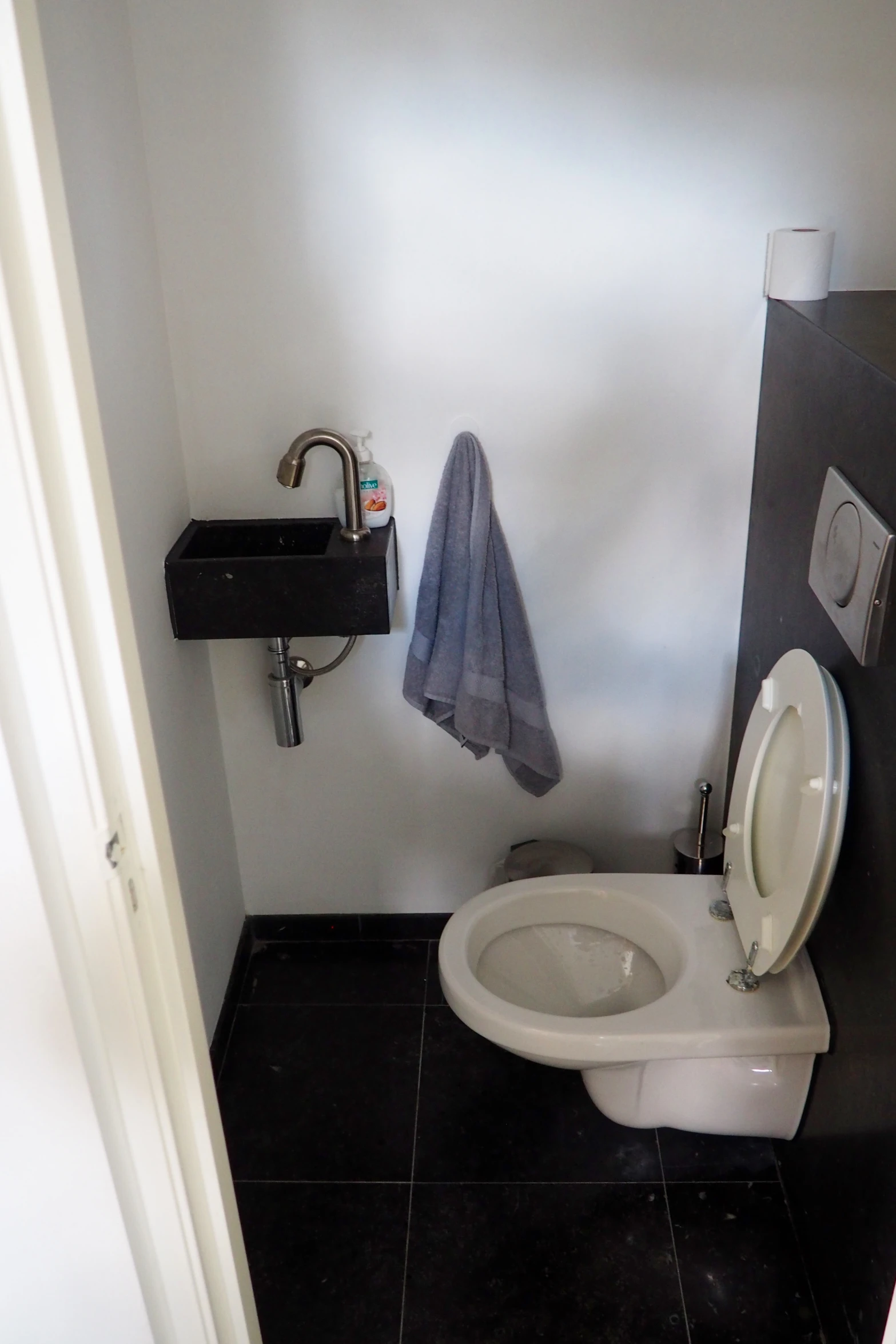 a restroom stall with toilet and sink in it