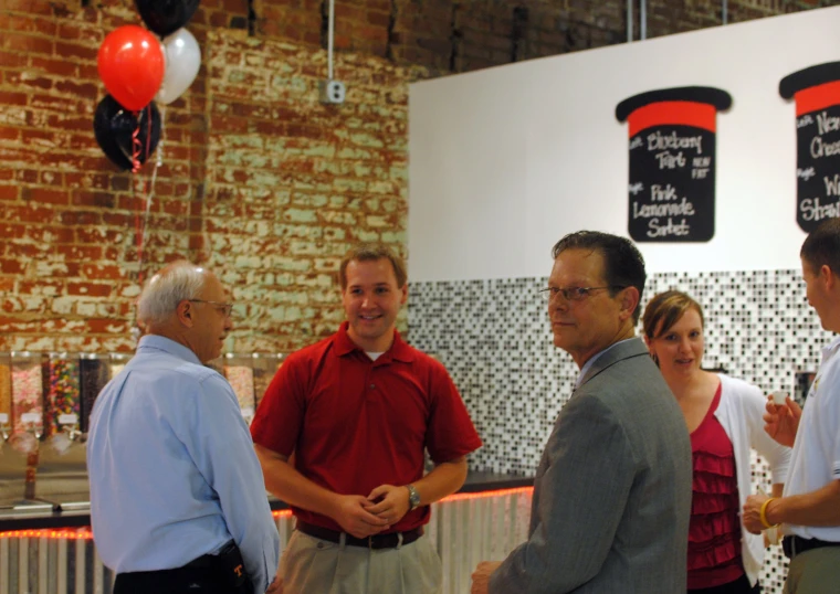 a man in a suit and other people in red shirts