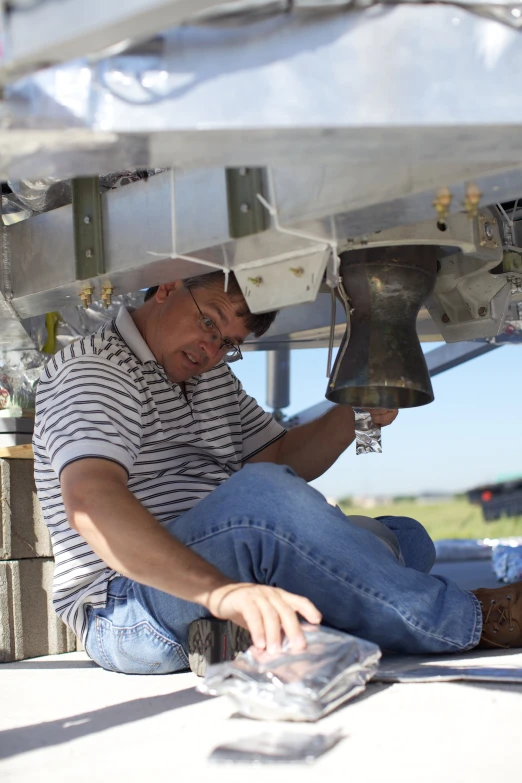 an older man sits under an overhang reading