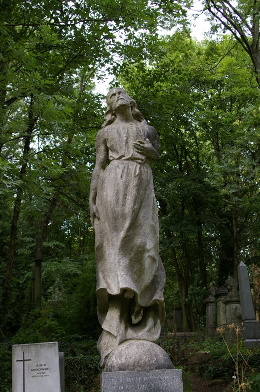 the statue in the graveyard features a person carrying a cross