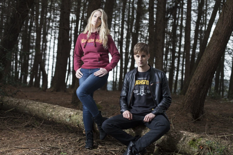 a man and woman are posing in front of the woods