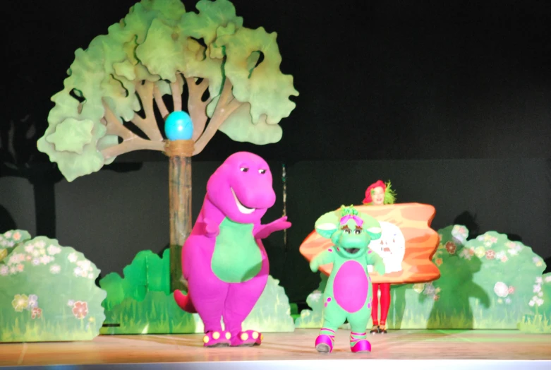 two little dino children are performing in front of trees