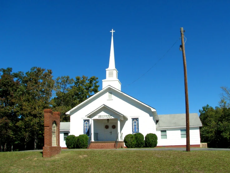 a large church in the country with trees and grass