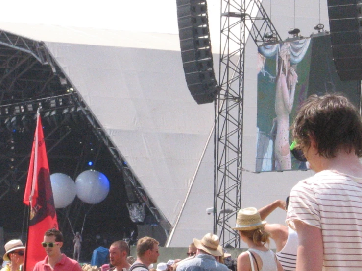 a man on the street near people in front of a stage