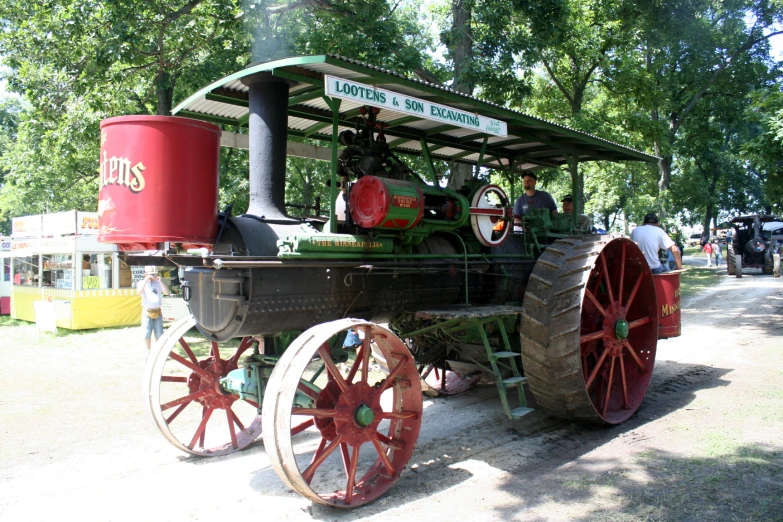 an antique tractor with old farm wheels sitting on display