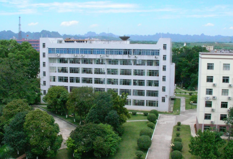 an aerial view of buildings, including one with windows, and a green lawn