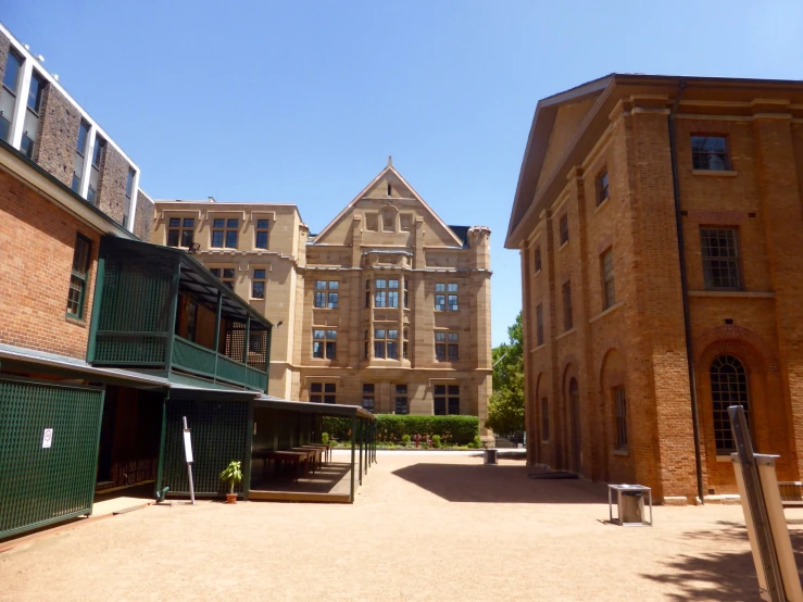 the courtyard of a building with a green fence