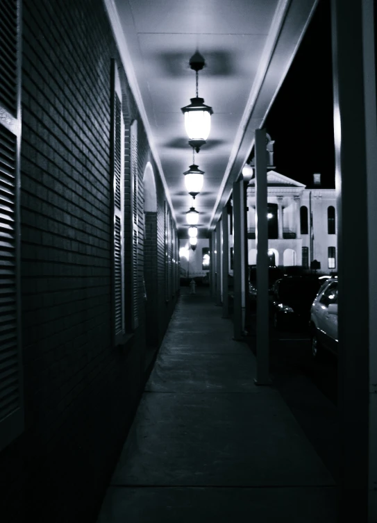 a building with a walkway between it and cars parked at the end