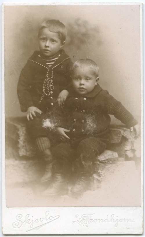 a sepia image of two children in suits