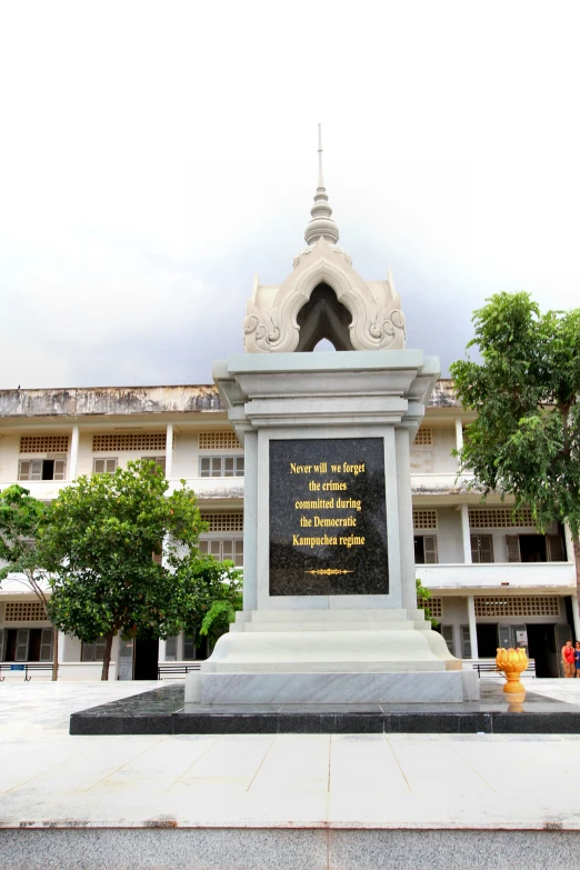 a statue with a sign on it in front of a building