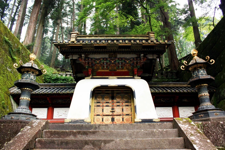 a set of stairs with a wooden door in between two columns