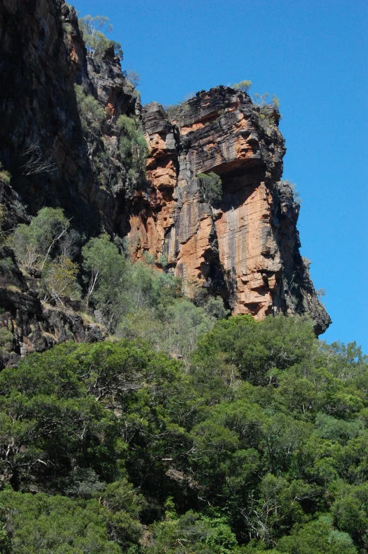 trees line the slope and rock formations