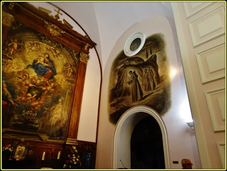 ornate mural in large church above door to entry